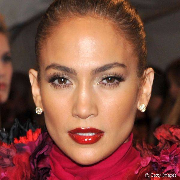 Em um evento de moda em Nova York, o batom vermelho com efeito de verniz deixou os l?bios de Jennifer Lopez mais volumosos (Foto: Getty Images)